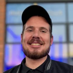 Cameron Roberts smiling in a black cap